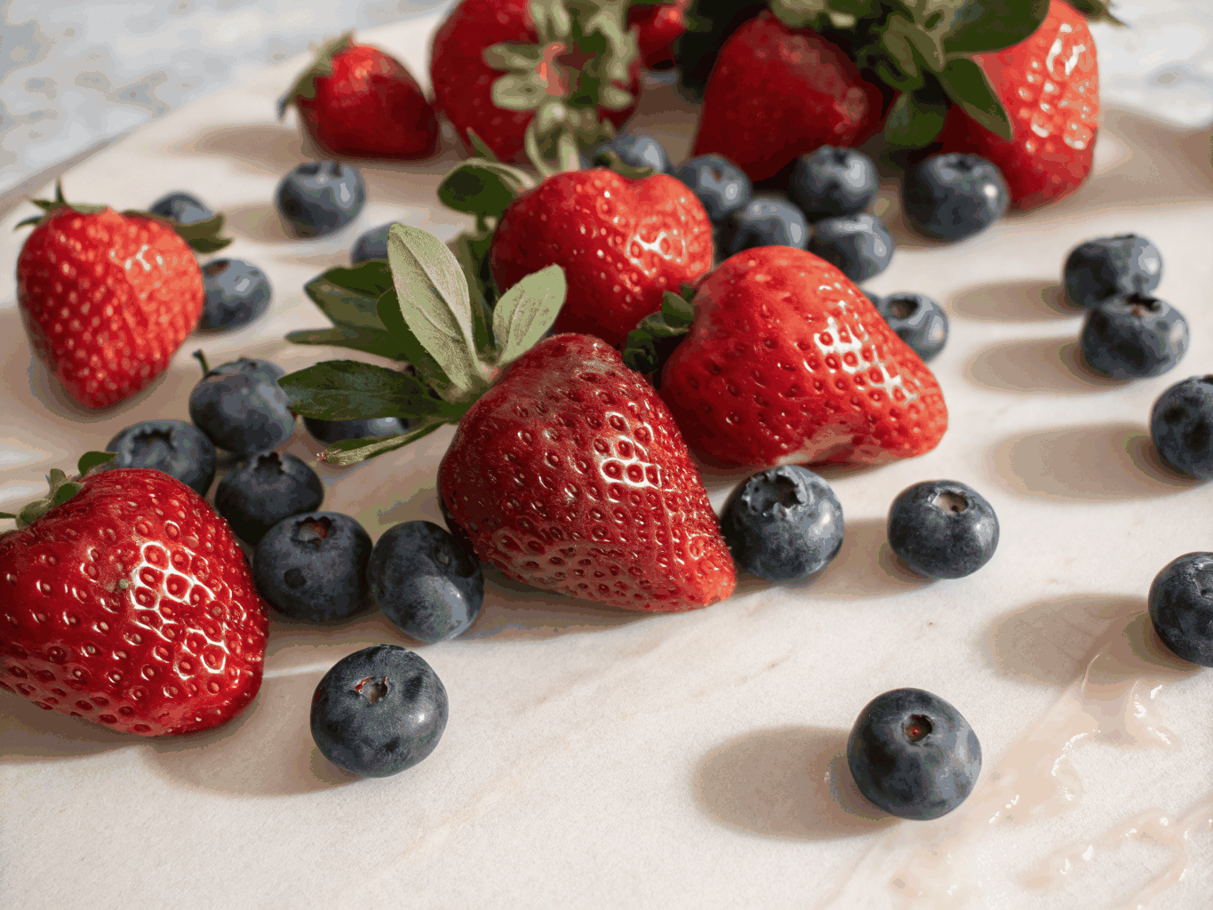 Potted strawberry and raspberry plants with ripe red fruit